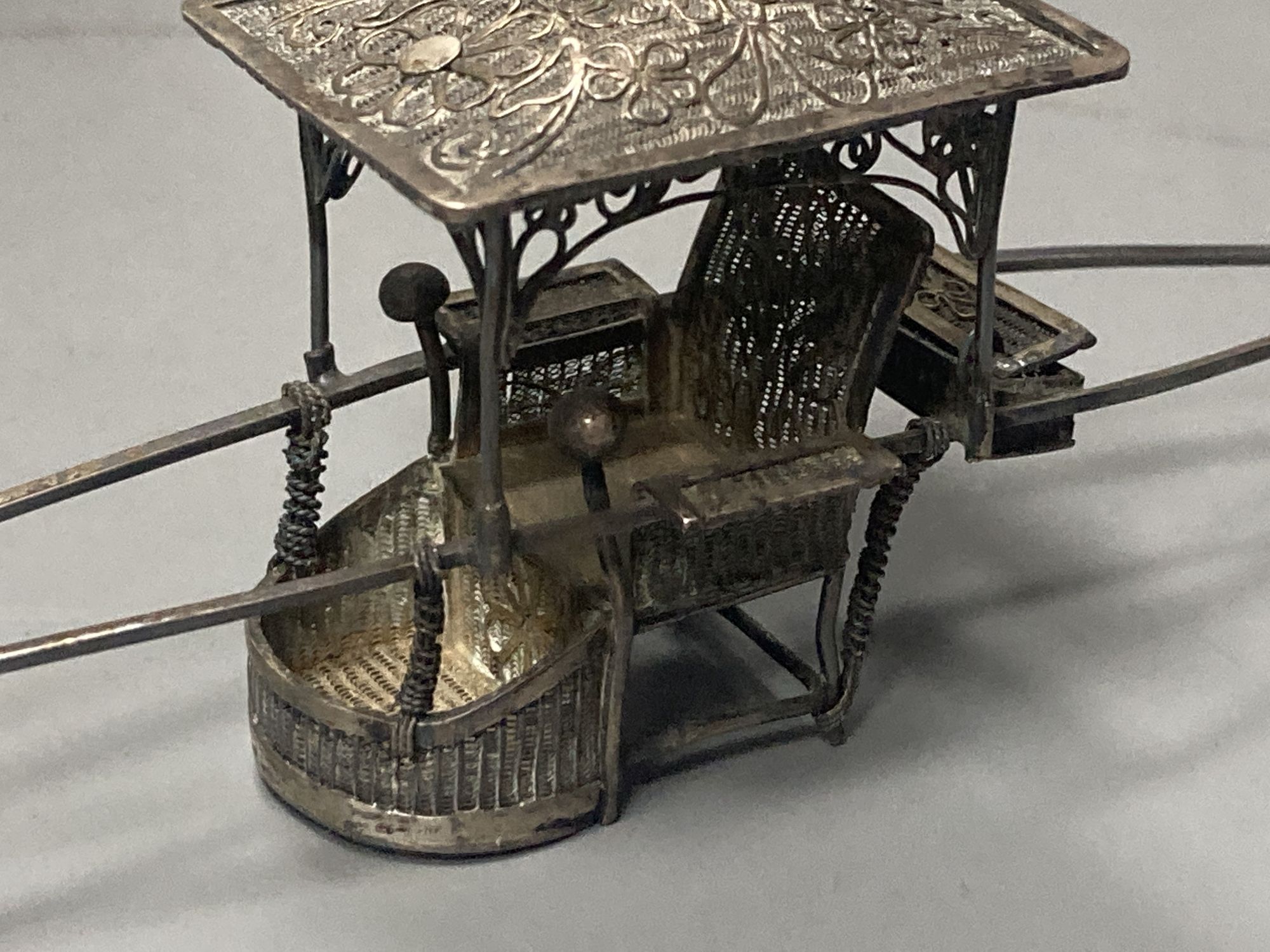 A group of Chinese white metal models of a sampan by Wang Hing, rickshaw and sedan chair etc.